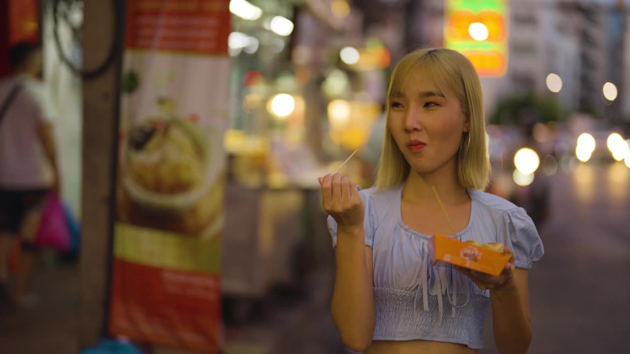 泰国华裔游客在曼谷唐人街的瑶瓦路闲逛和品尝街头小吃视频素材