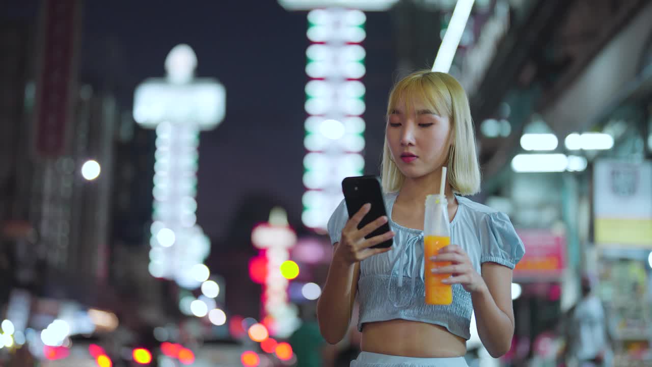 年轻的亚洲人喜欢在晚上用智能手机在曼谷唐人街瑶池游玩视频素材