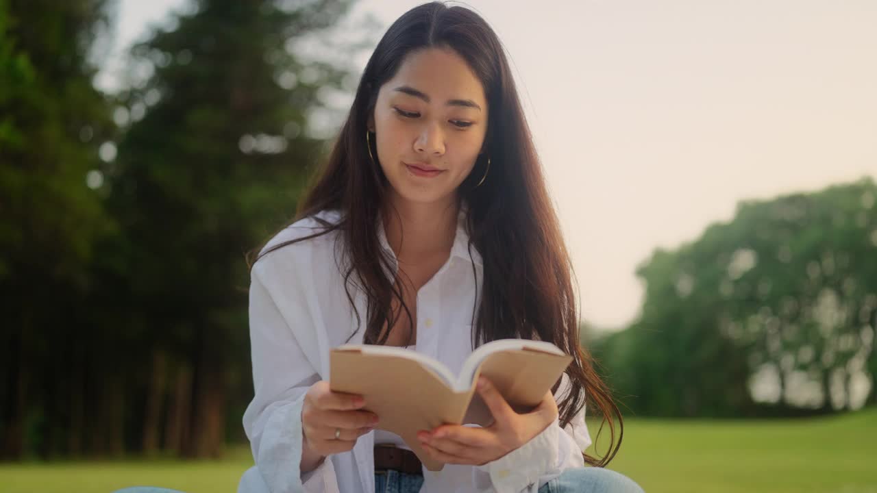 一名年轻女子在阅读书籍后休息片刻，用可重复使用的水瓶来补充饮料视频下载