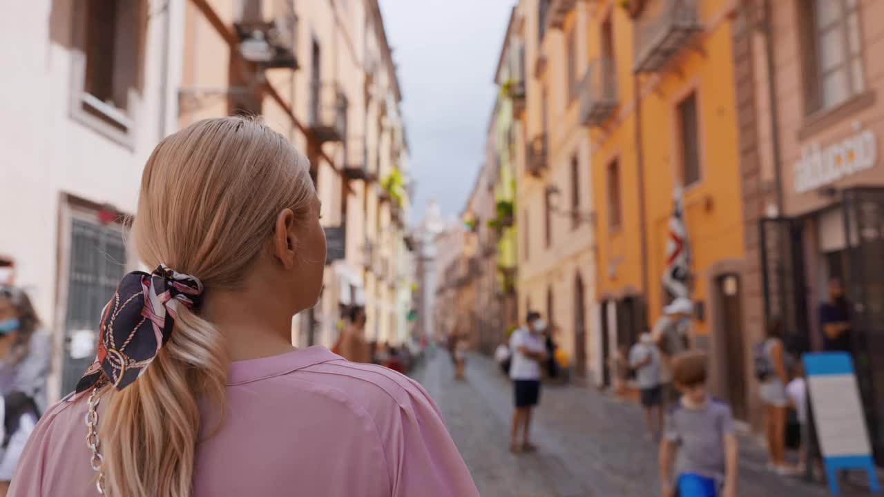 一个金发女人走在街上，卡利亚里，意大利。视频下载
