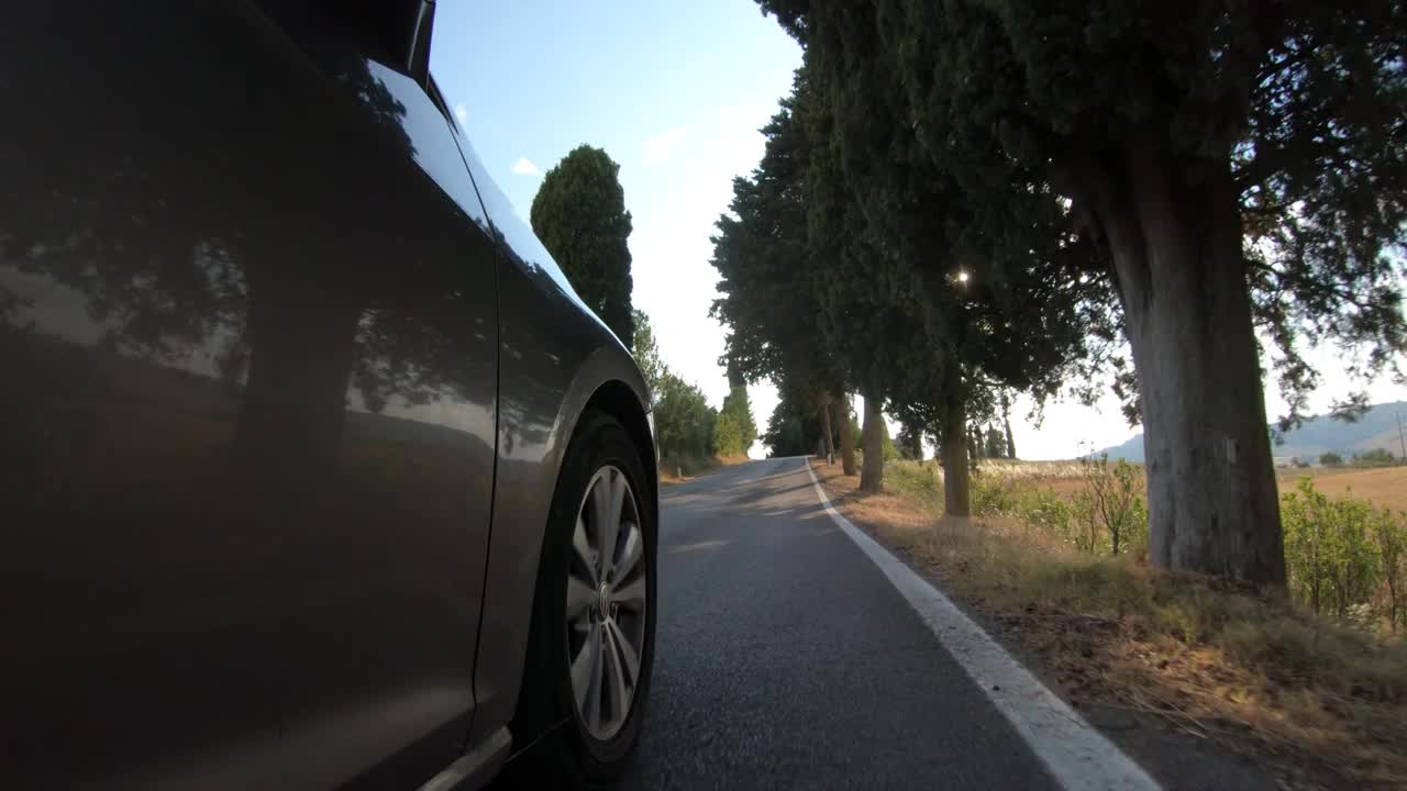 低角度拍摄的一个旋转的汽车车轮在乡村道路视频下载