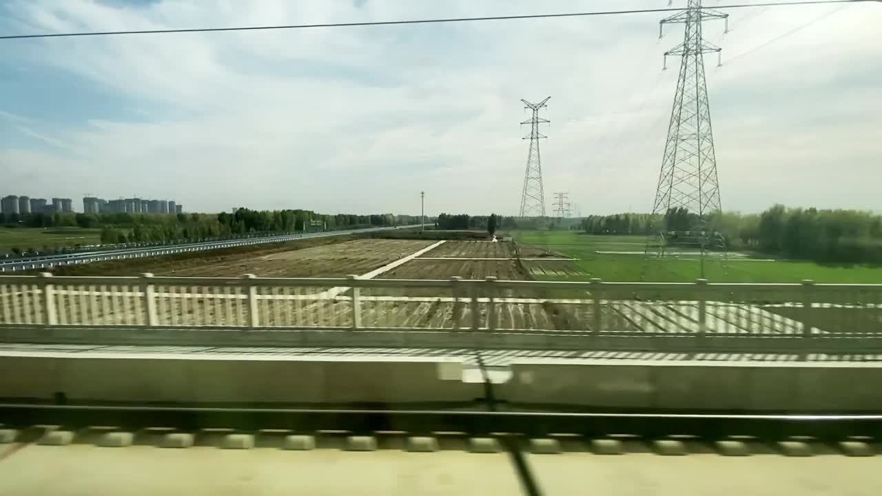在火车上看着窗外，经过城市郊区的公路和农场运河视频下载