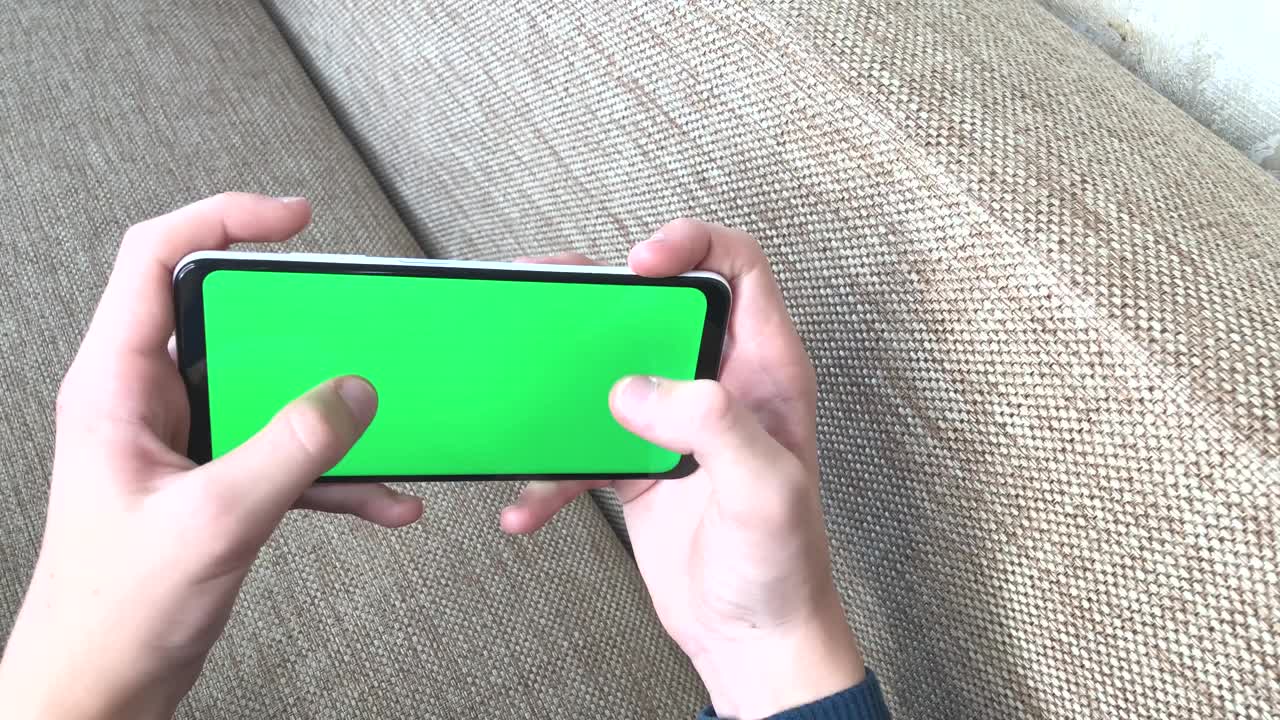 手青少年使用手机，智能手机的绿色屏幕色度键用于复制空格文本视频素材