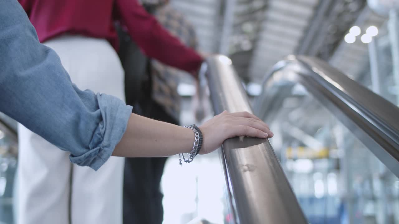 机场一名女子右手扶着自动扶梯扶手视频素材