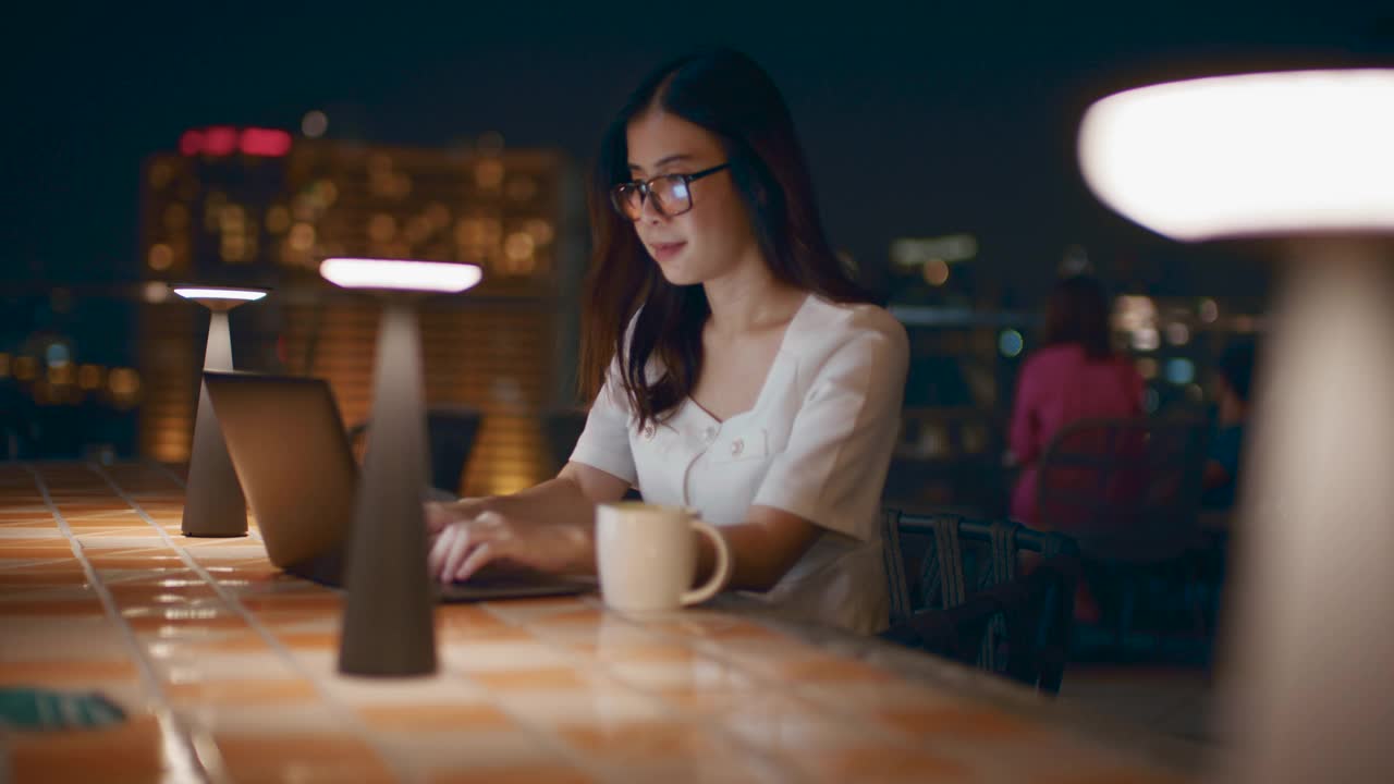 晚上在户外使用笔记本电脑的女人视频素材