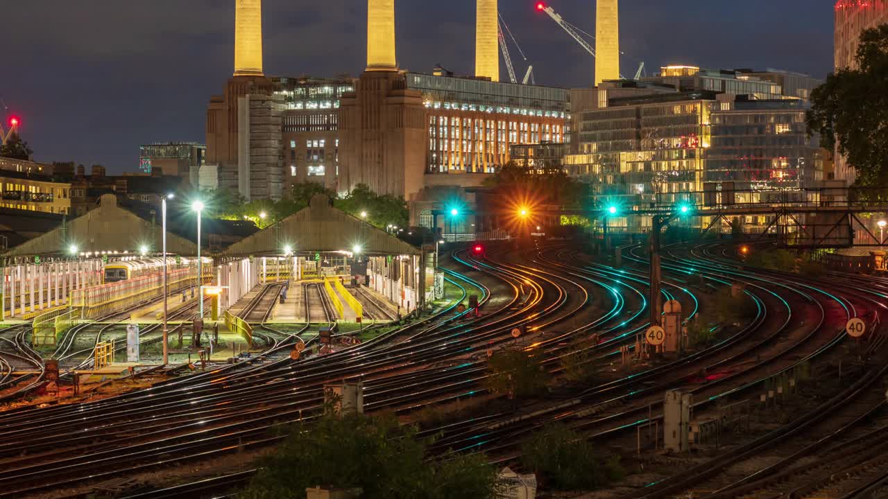 黄昏时英国伦敦巴特西发电厂和火车站的景色- 4k延时(Zoom Out)视频下载