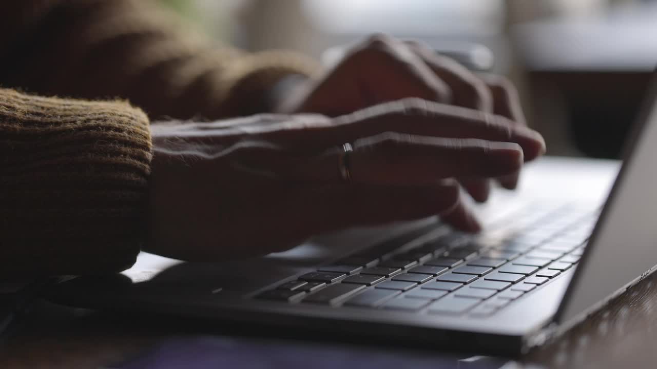 男人的手在木桌上的笔记本键盘上打字。用网络技术工作的人。视频素材