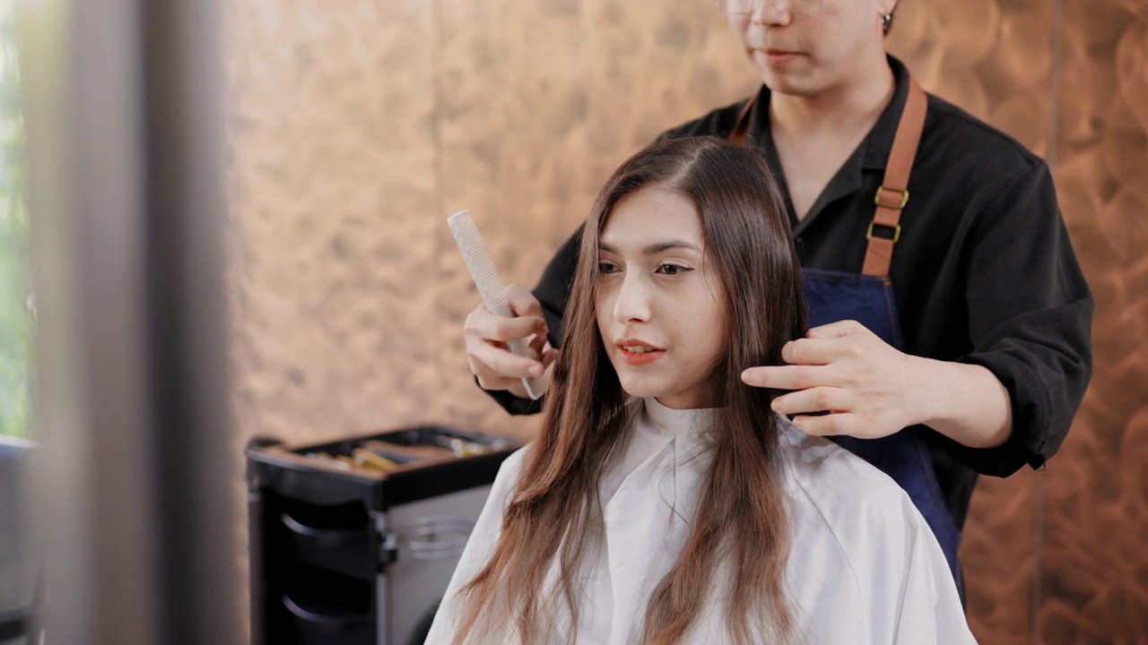 亚洲专业发型师正在美容院为顾客理发。有吸引力的美丽的亚洲妇女坐和等待剪新发型。视频素材