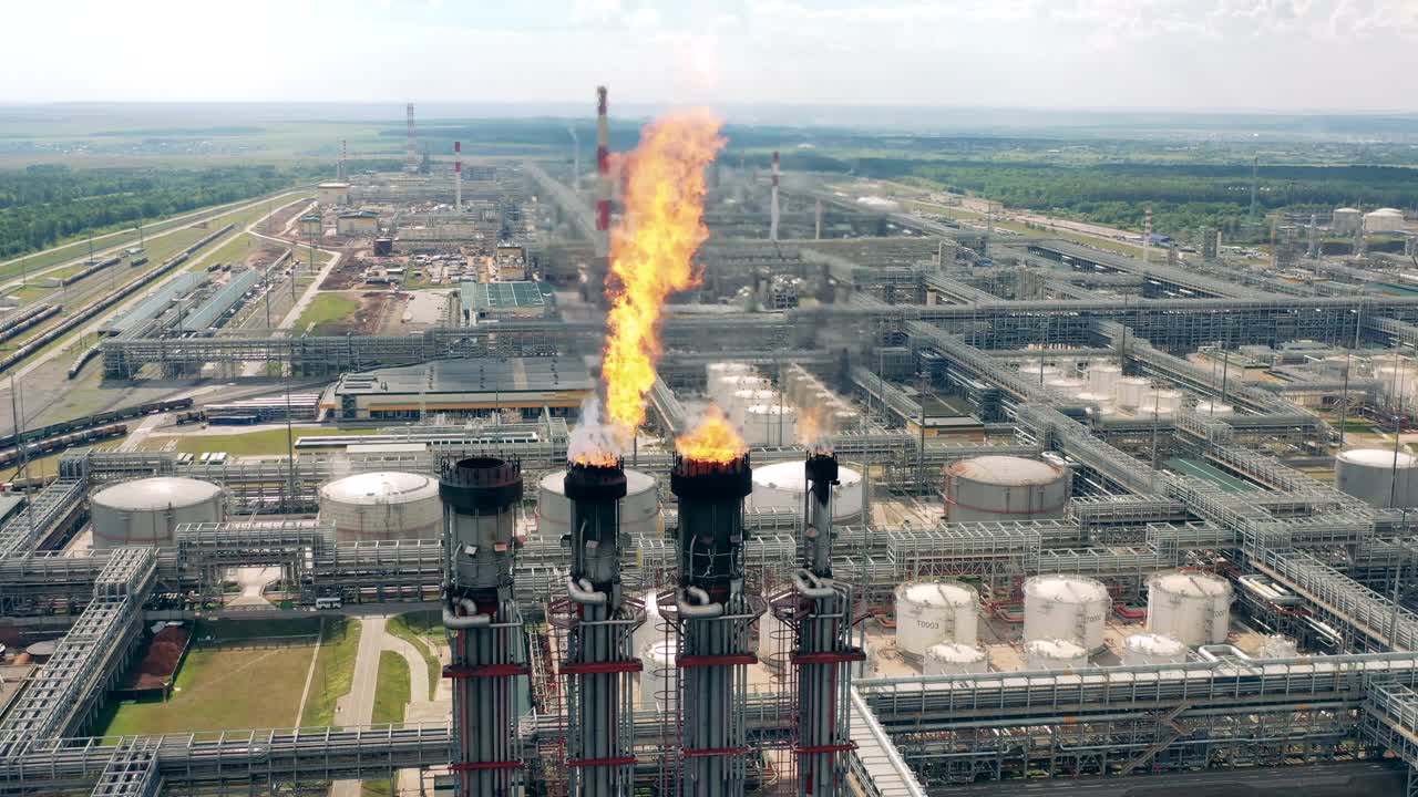 从上面拍摄的炼油厂的燃烧烟囱。空气污染的概念。视频素材