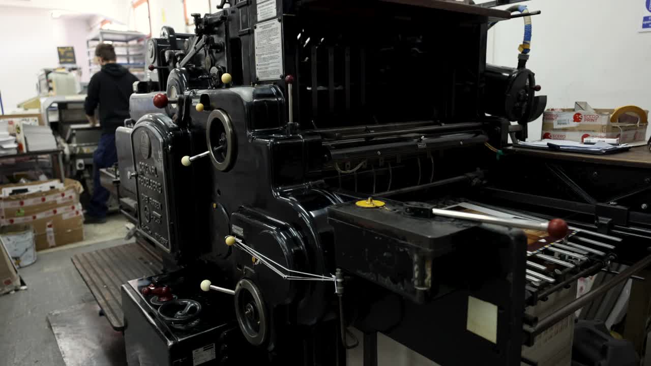 b卷自动机器对印刷介质进行分类和堆叠，而无法辨认的工人在印刷车间，在后台工作视频下载
