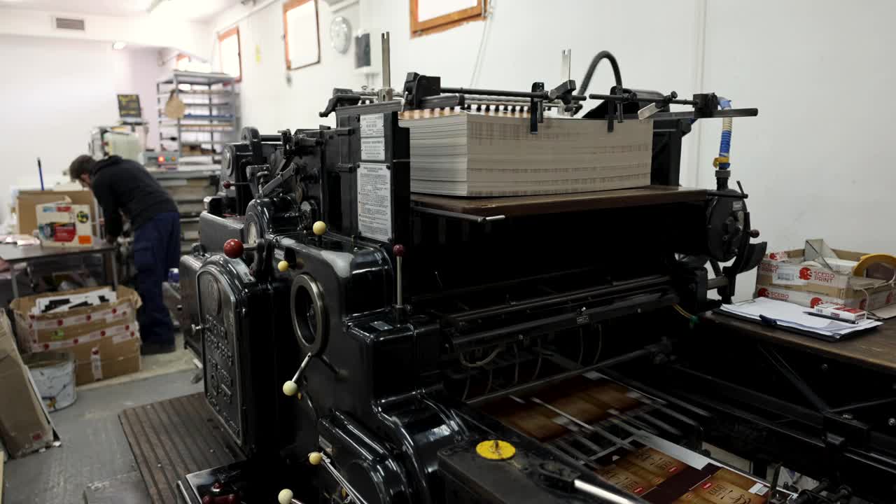 自动机器分类和堆叠印刷介质，而无法识别的工人在印刷车间，在后台工作视频下载