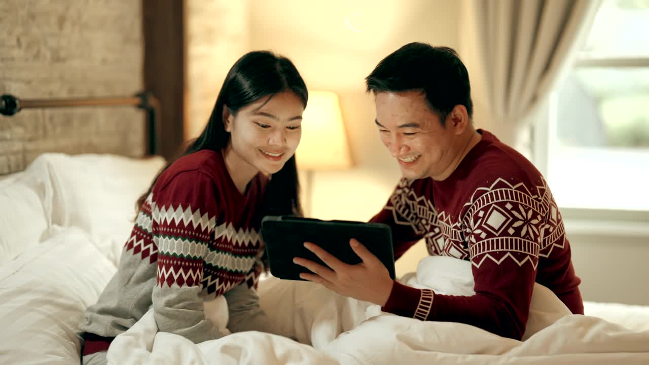 夫妻坐在床上在节日庆祝圣诞季节视频下载
