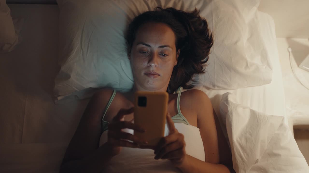 躺在床上浏览社交媒体的女人视频下载