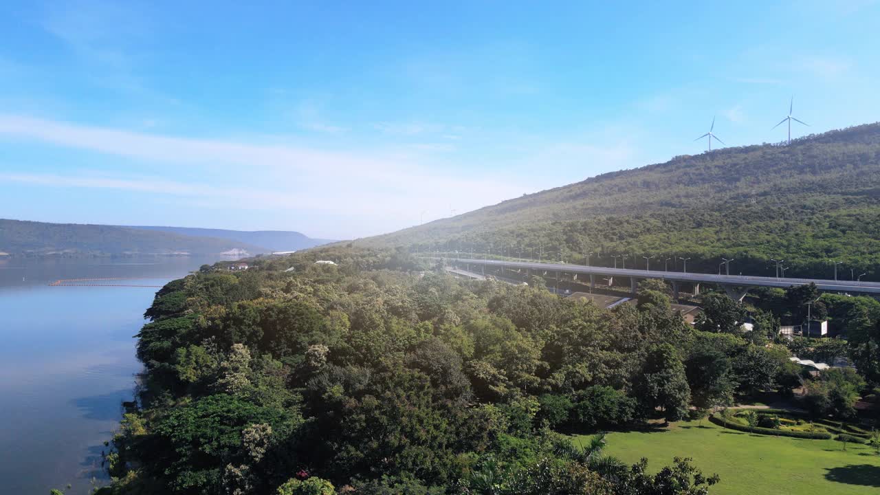 空中无人机超延时延时美丽的高速公路在绿色森林与大坝在公路的一边之间的山。视频下载