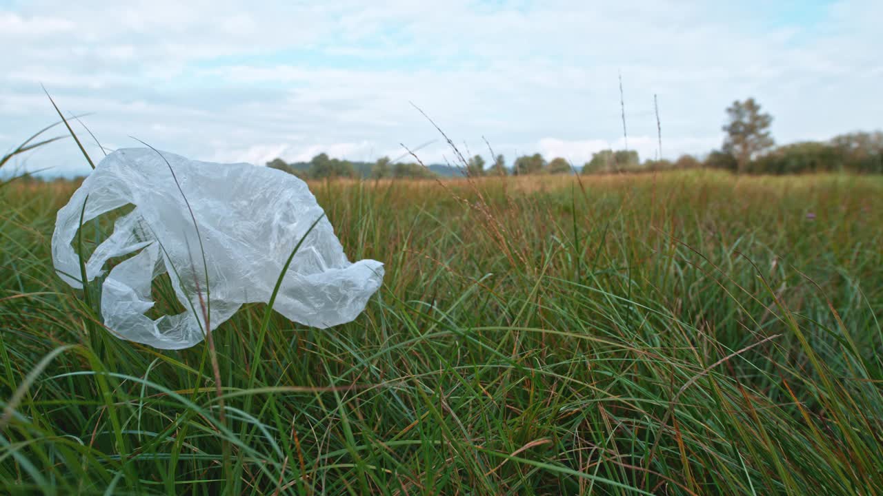 随风飘过草地的塑料袋视频素材