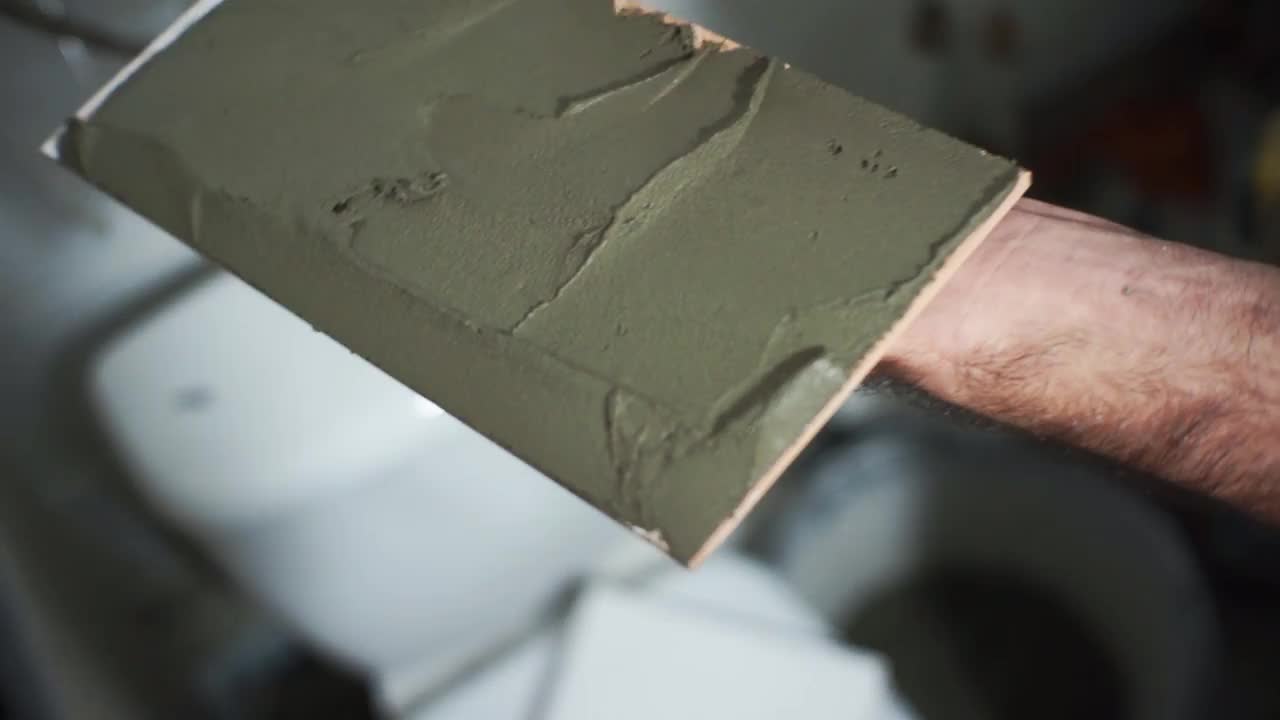 在瓷砖上涂瓷砖胶水的铲刀。视频素材