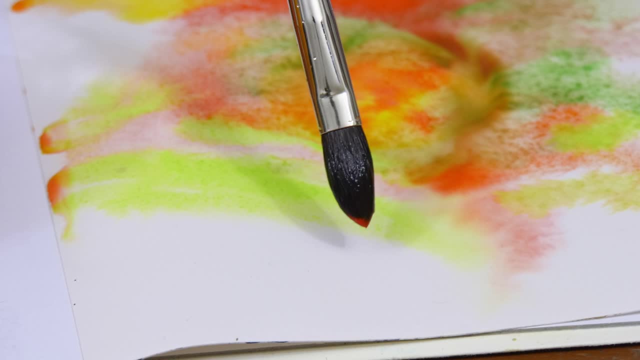 艺术家用水彩颜料在白色画布上画一个抽象的人物。视频下载
