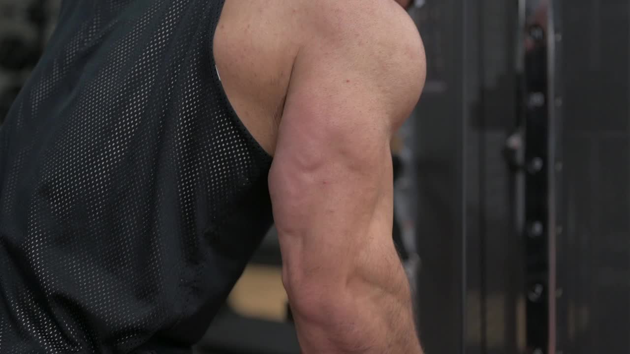 强壮的健美男性在运动健身馆进行三头肌拉重训练视频下载