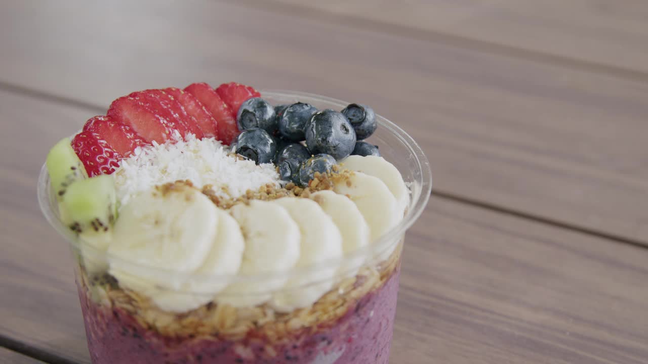 夏季户外木桌上健康巴西莓食物碗的手持特写视频素材