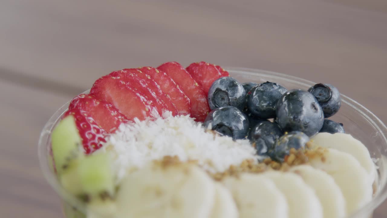 夏季户外木桌上的健康巴西莓食物碗的近距离手持微距拍摄视频素材