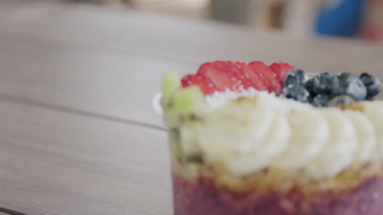 夏季户外木桌上的健康巴西莓食品碗的手持复制空间特写视频素材