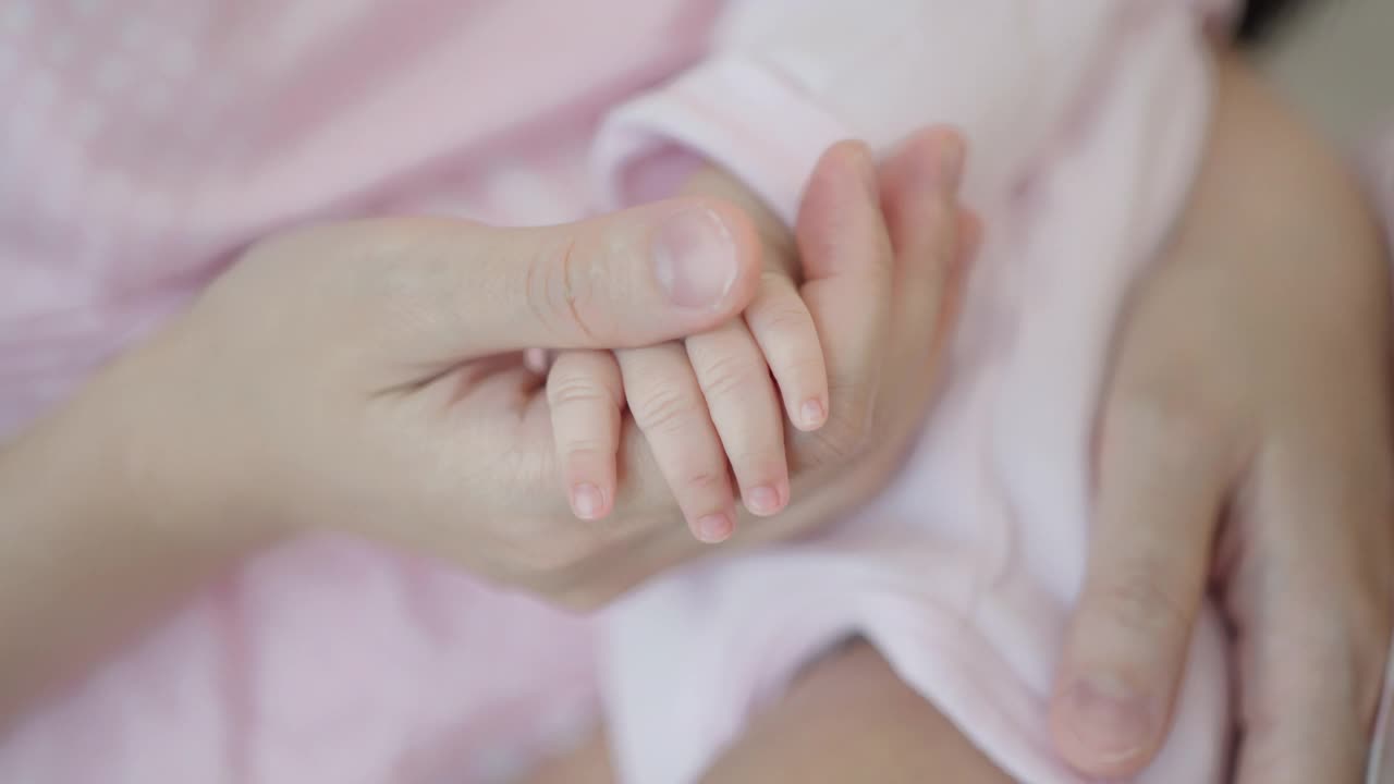 母亲轻轻地抚摸着婴儿的身体。视频素材