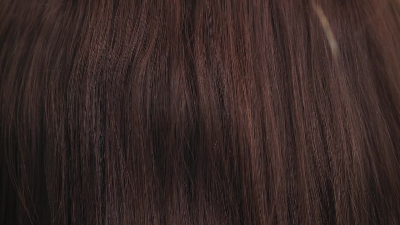 护发，梳子沿着美丽健康的长而流动的棕色头发靠近，纹理视频下载