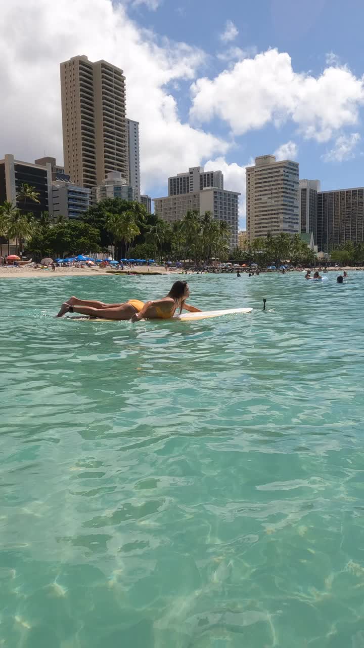 在夏威夷瓦胡岛威基基岛的钻石岬附近冲浪的女人。- - - - - -垂直格式视频下载