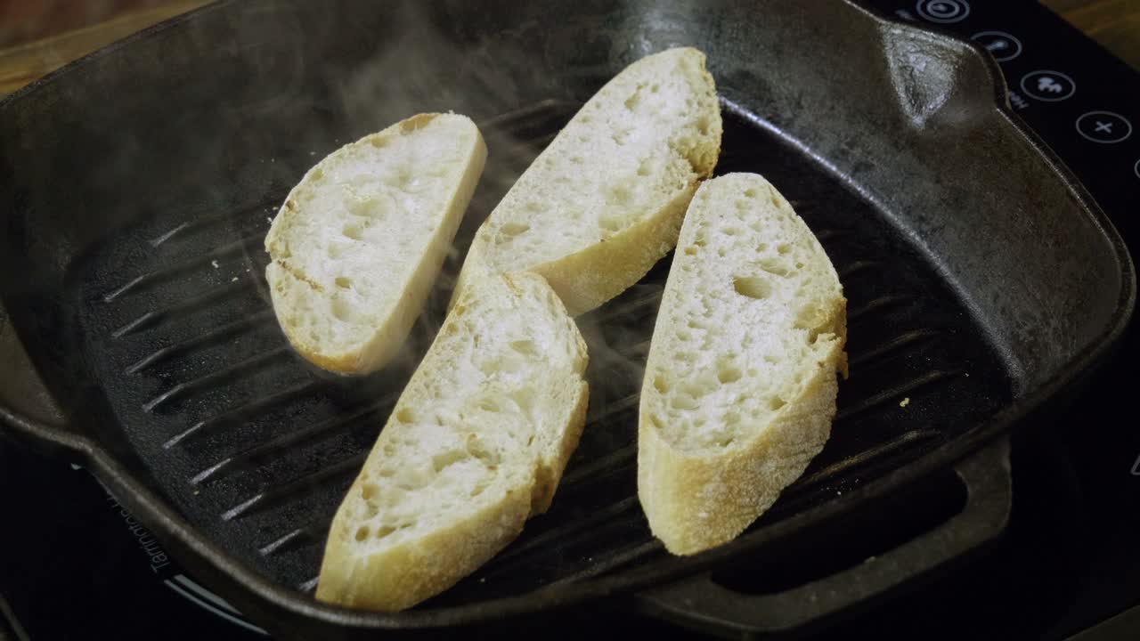 镜头中的法棍正在烤盘里煎制意大利意式烤面包。4 k视频下载