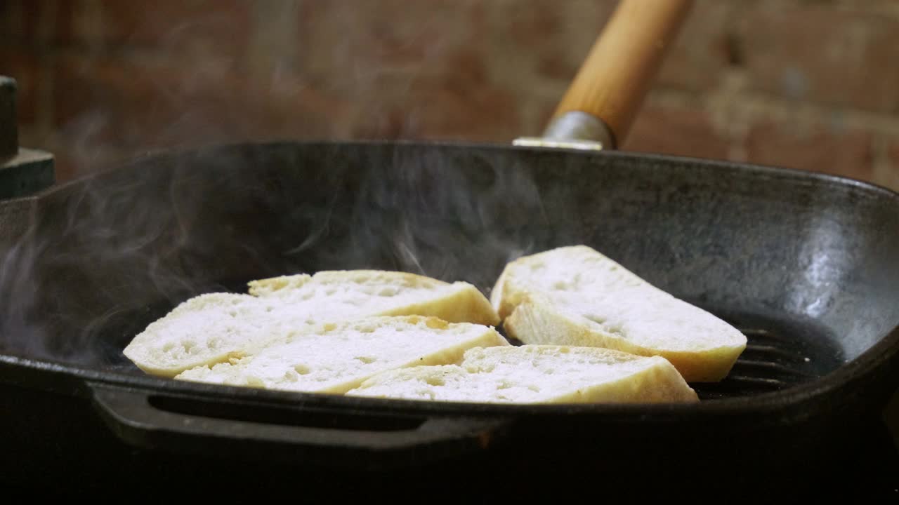 镜头中的法棍正在烤盘里煎制意大利意式烤面包。4 k视频下载
