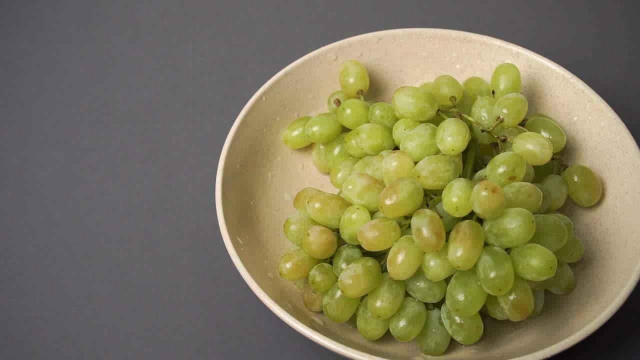陶瓷盘里有绿色的葡萄。视频下载