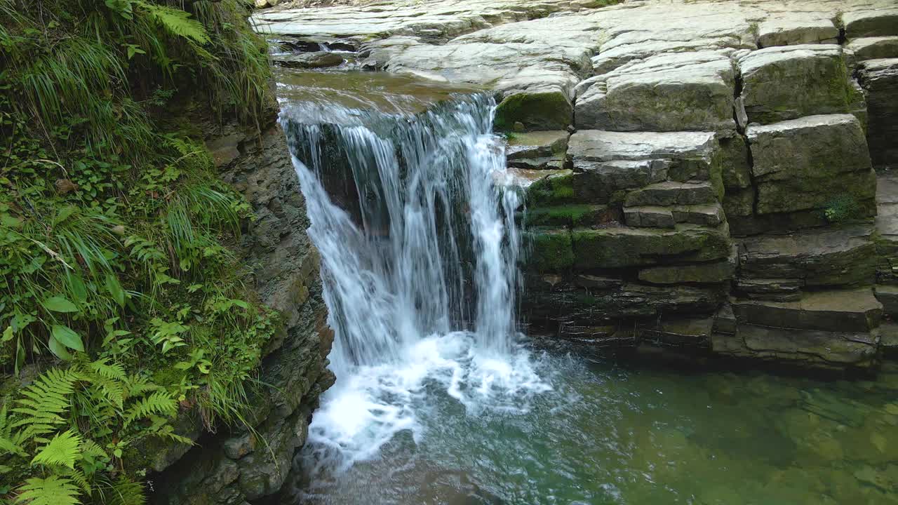 瀑布在山河与白色泡沫的水从岩石形成的夏季森林视频素材