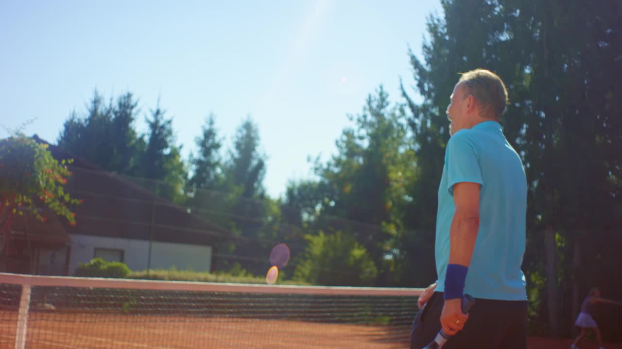 这是一个阳光明媚的日子，两个人打完网球后在外面握手视频素材