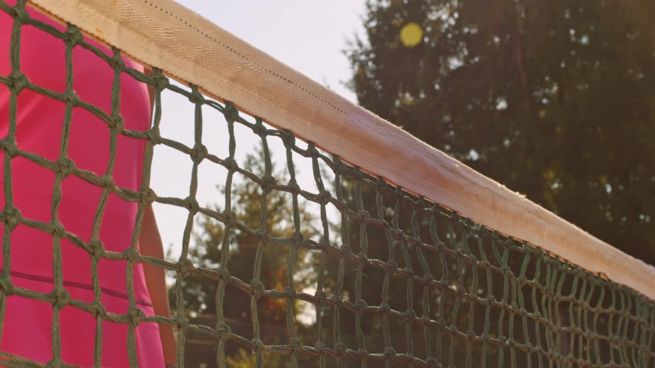 一名中年女子在阳光明媚的网球场上与网球对手握手视频素材