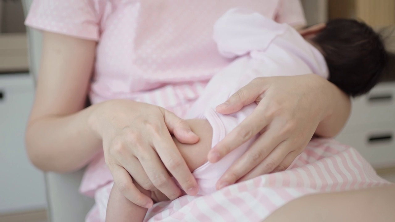 亚洲年轻母亲母乳喂养她的孩子。视频下载