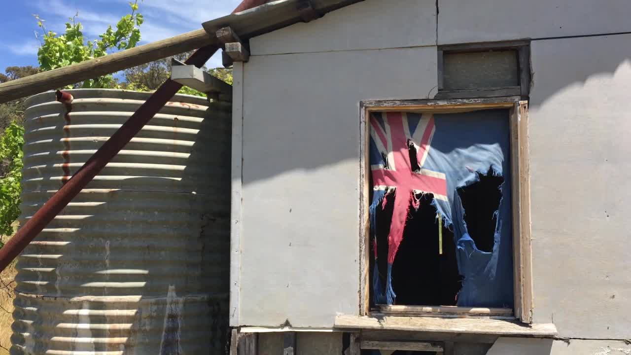 旧农舍窗户上挂着一面澳大利亚国旗视频下载