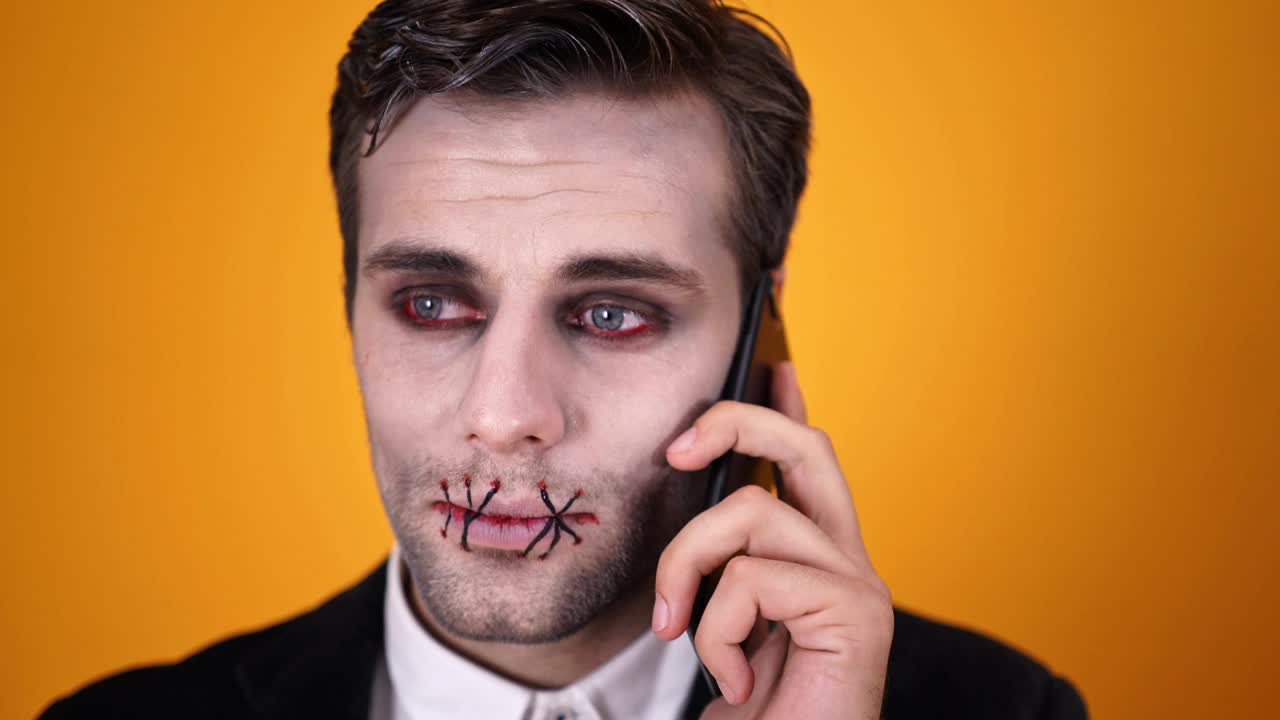万圣节化妆，嘴巴被缝合的困惑死去的新郎试图用智能手机说话视频素材