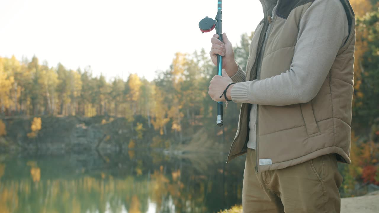 特写镜头:秋天，在可爱的湖里，男人们手拿鱼竿捕鱼视频素材