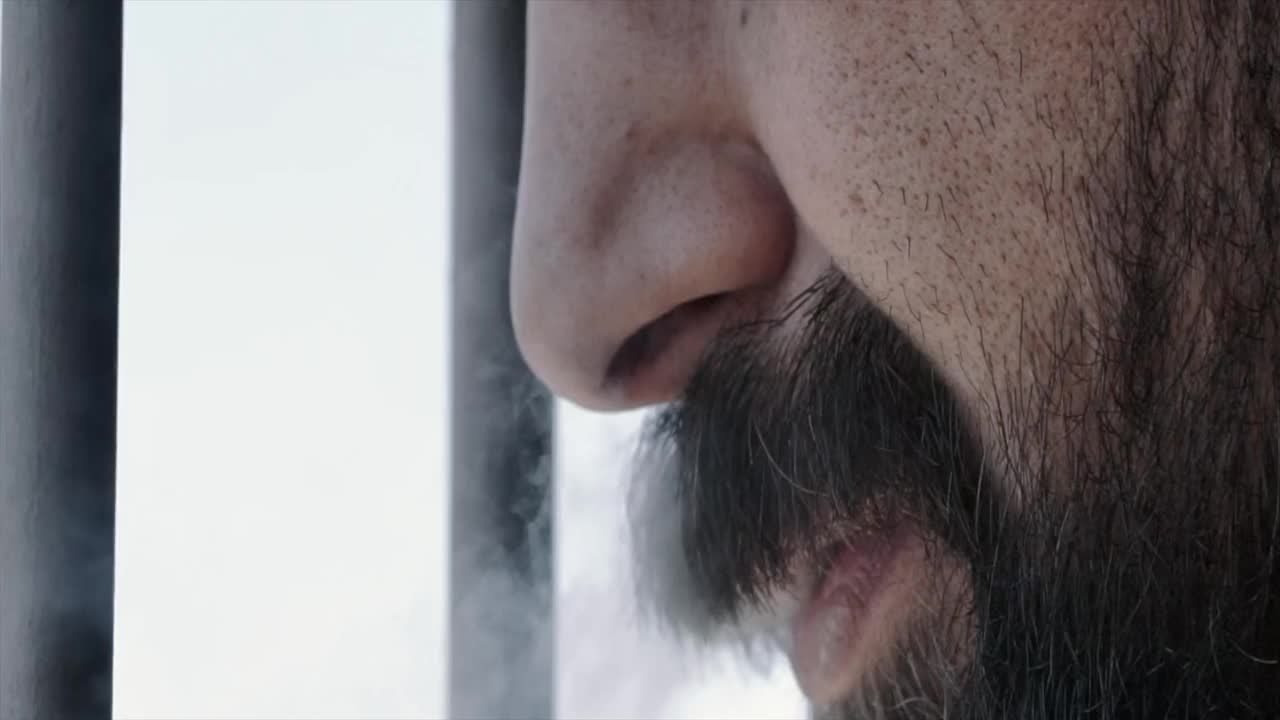 一个男人吸烟的特写聚焦在嘴巴上视频下载