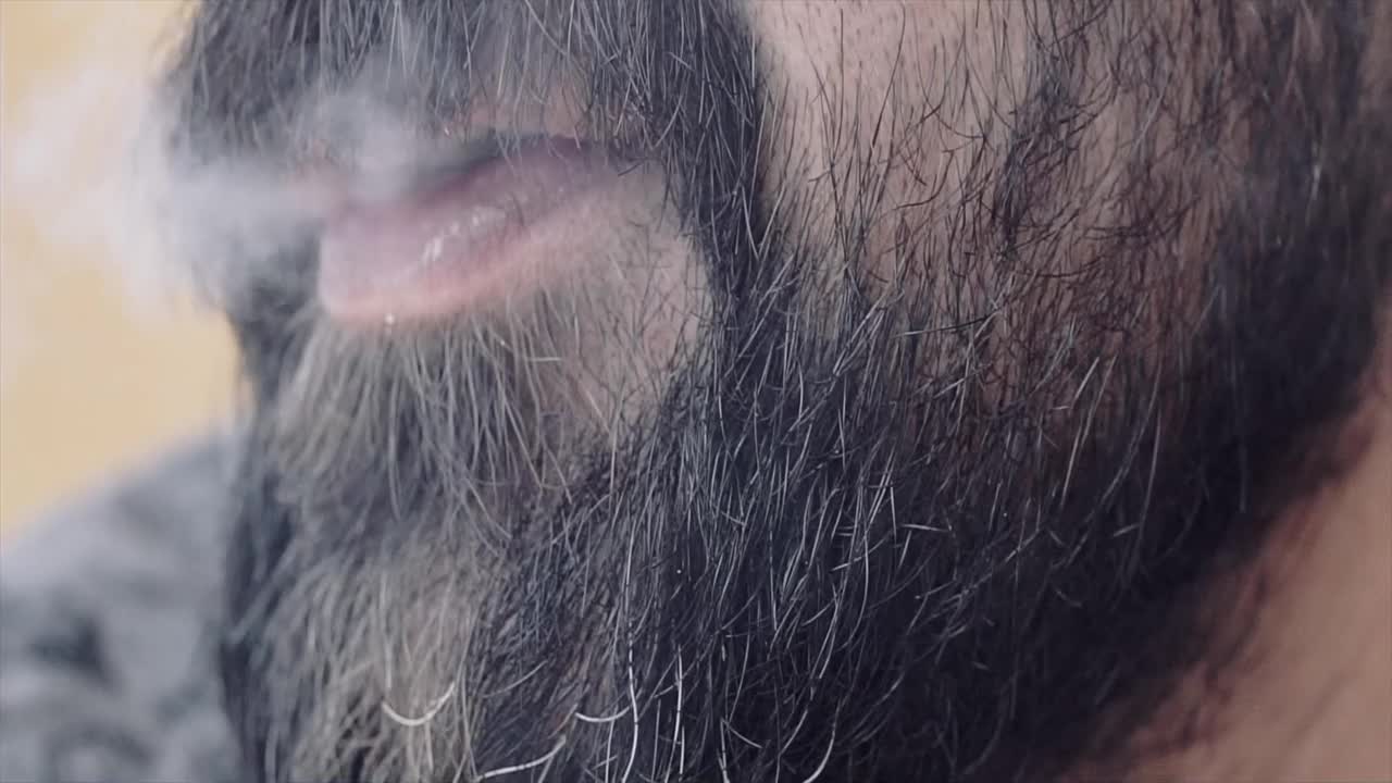 一个男人吸烟的特写聚焦在嘴巴上视频下载