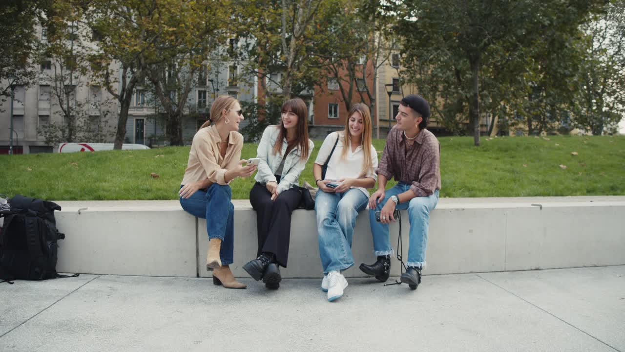 四个朋友在城市里一起玩，看着智能手机视频素材