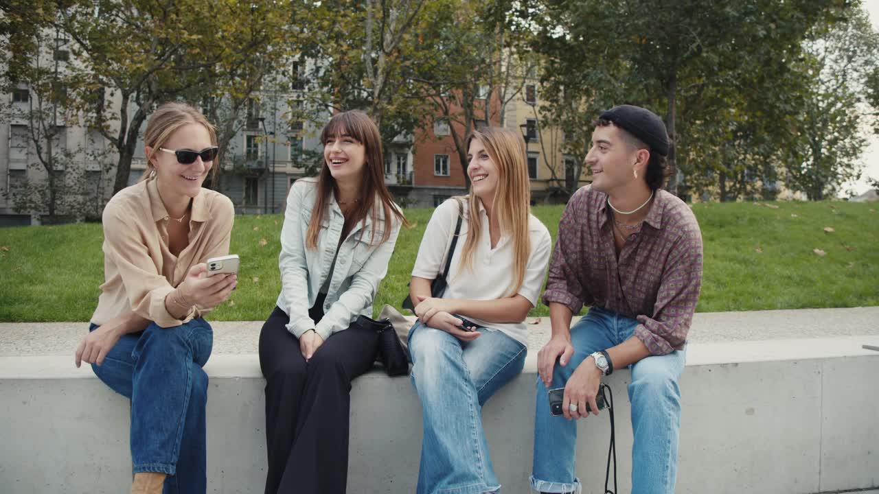四个朋友在城市里一起玩，看着智能手机视频素材