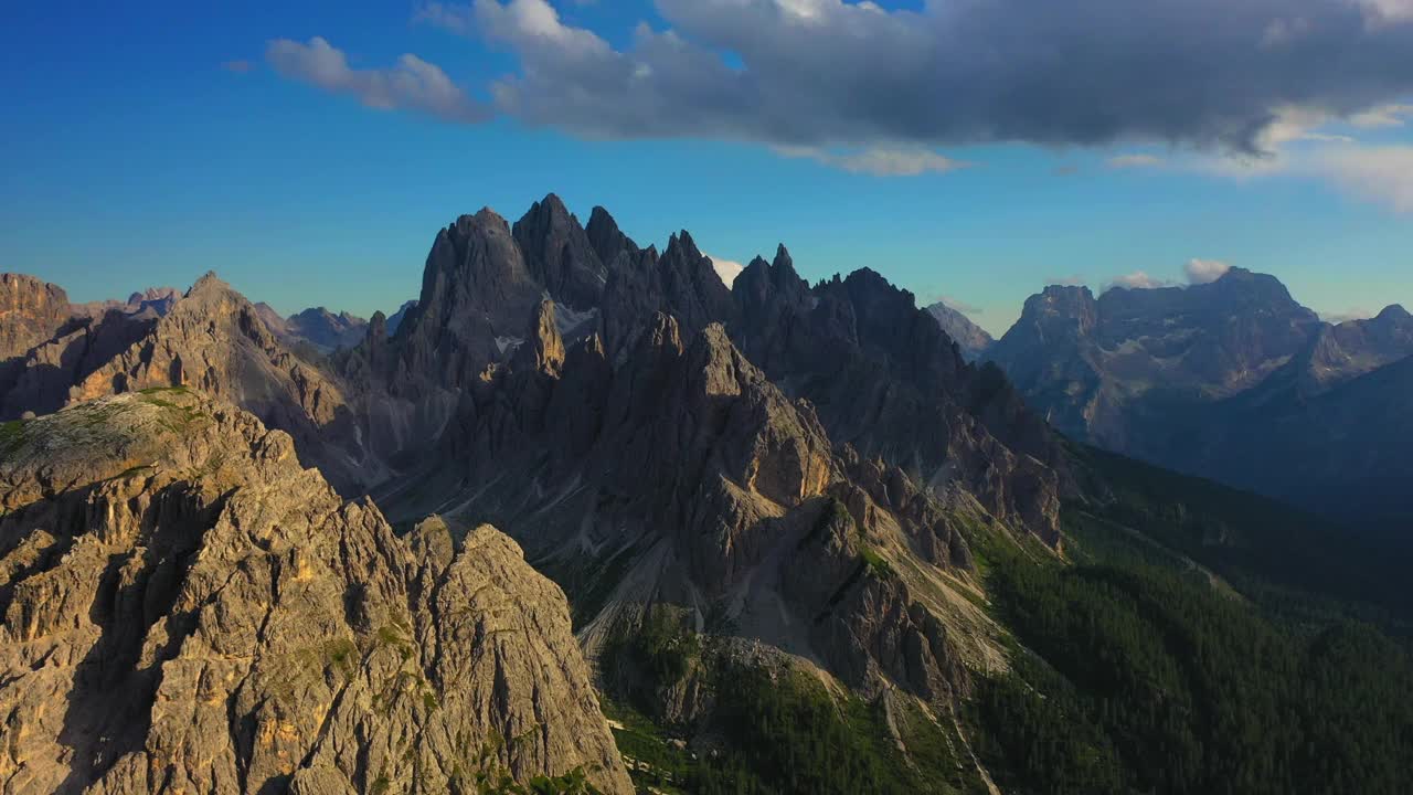 空中美丽的岩石形成在多云的天空，无人机飞越树木-特里Cime Di Lavaredo，意大利视频下载
