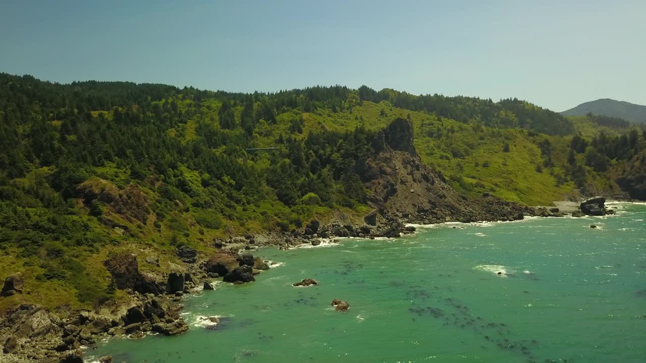 航拍拍摄的海浪冲击海岸线在阳光明媚的日子，无人机飞越大海反对蓝天-俄勒冈海岸，俄勒冈视频下载