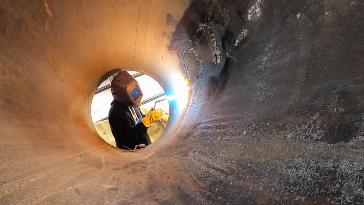 男焊工在车间工作时使用焊枪的锁定镜头-加利福尼亚州蒙特利视频下载