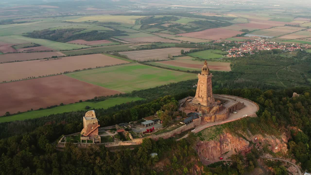 空中拍摄山顶上著名的纪念碑，无人机飞越树木-图林根州，德国视频下载