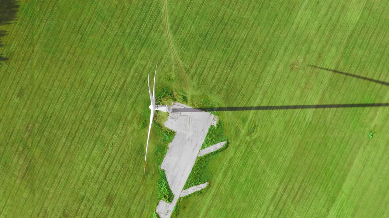 大型风力涡轮机和它在绿色田野上的长长的影子视频素材