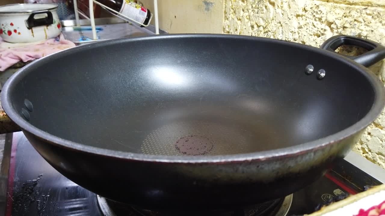 在加热的煎锅里倒入油。视频素材