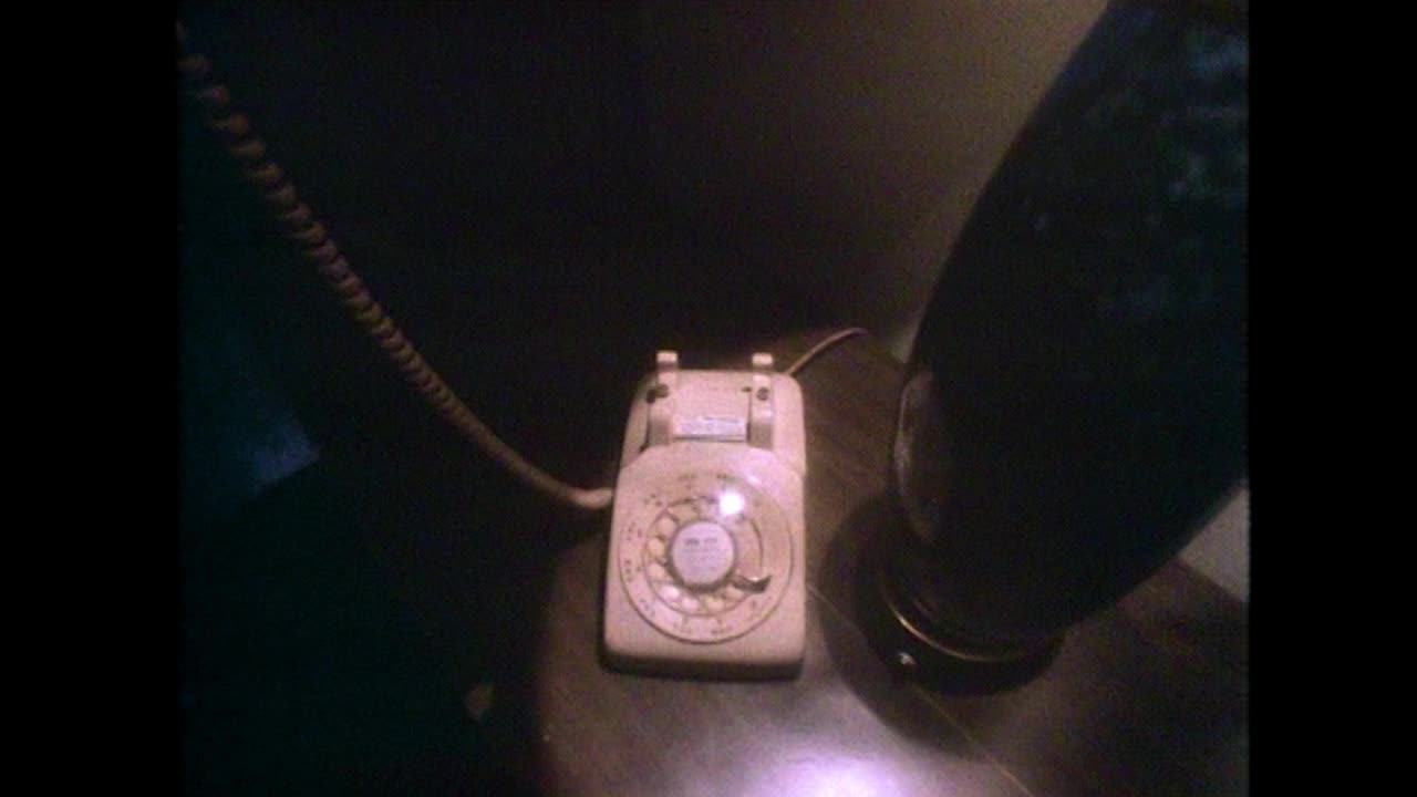 床头柜上的旧塑料转盘电话正在使用;1981视频下载