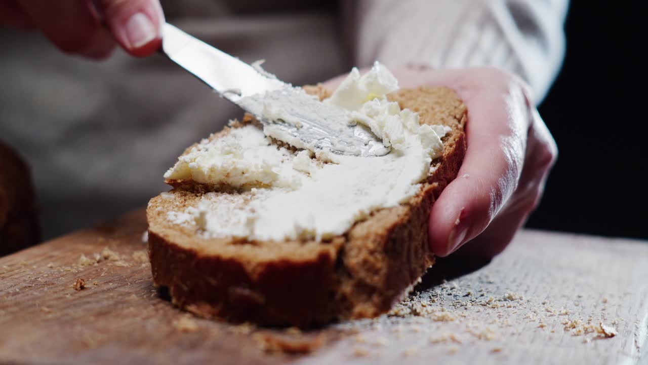 人类的手在一片面包上涂奶油芝士视频下载
